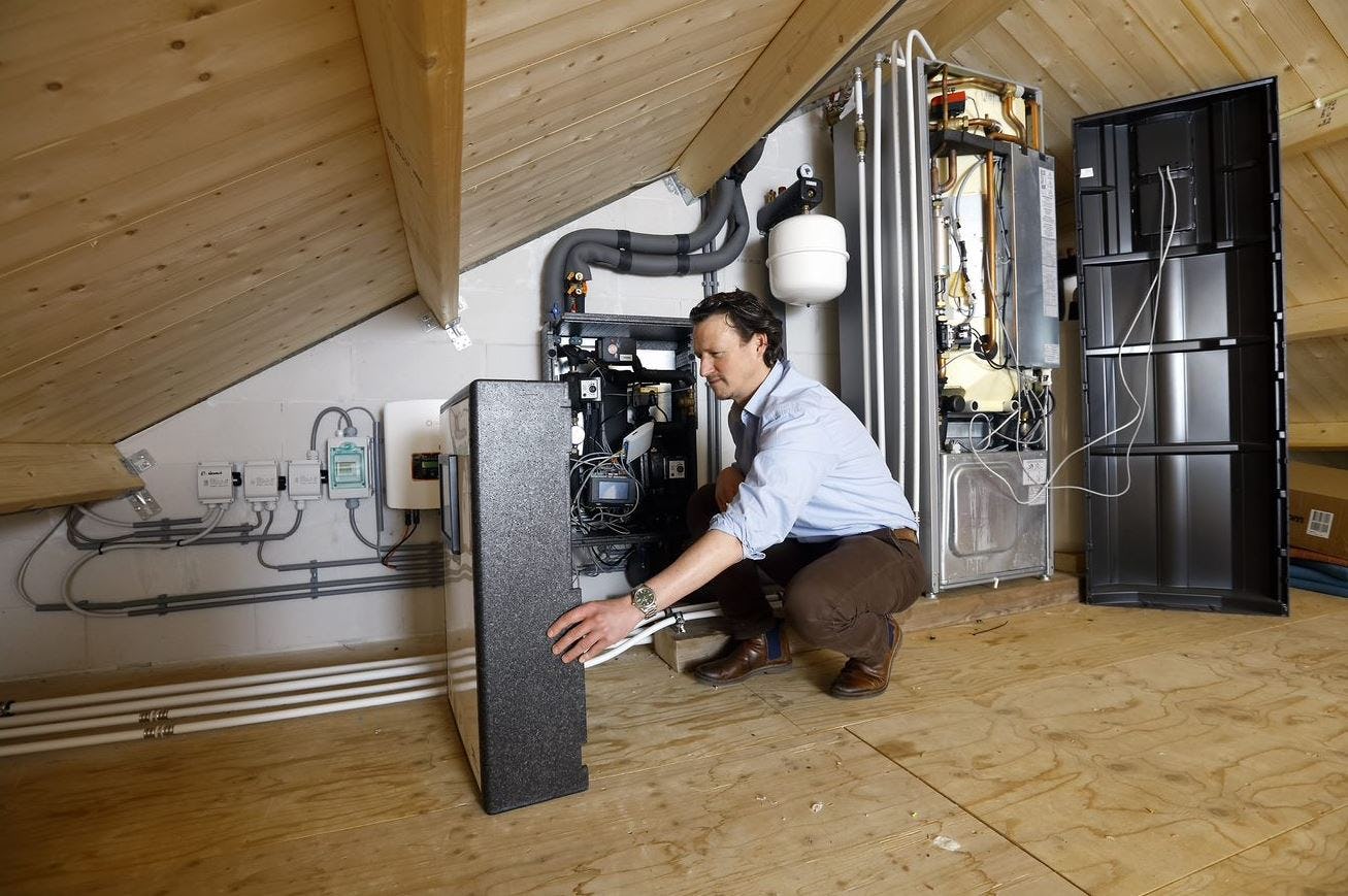 Dr.ir. Ivo Ponthof bij de huisinstallatie die de PVT-panelen aan het zonnewarmtenet koppelt. (Foto: Sam Rentmeester )