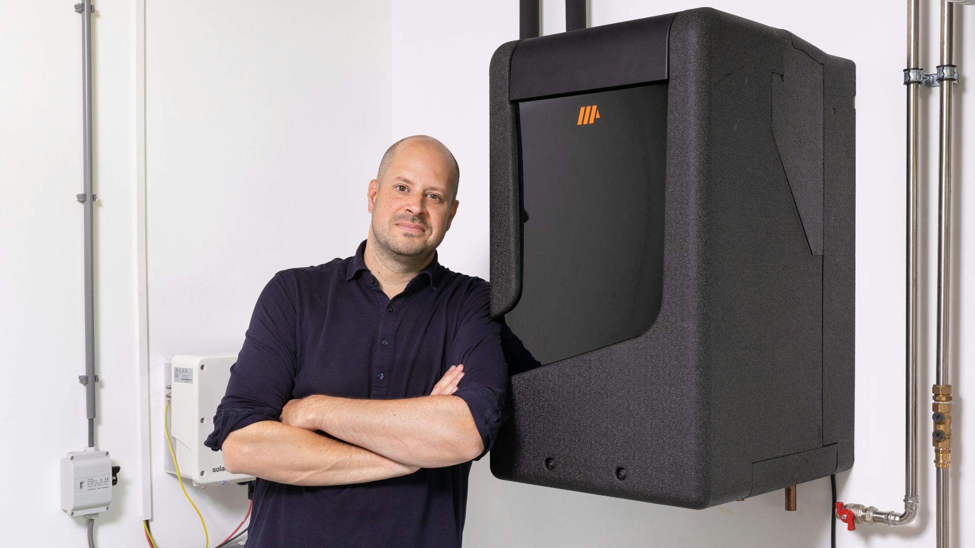 Jorrit Lootsma naast de PVT-warmtepomp van Triple Solar. Foto: NFP Fotografie.