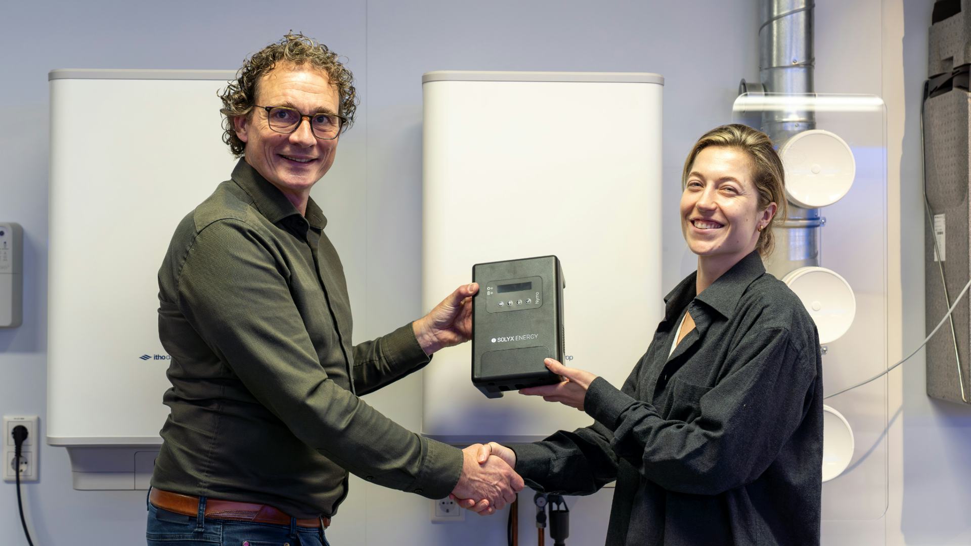 Mark Bussman van Itho Daalderop en Emma Snaak van Solyx Energy schudden elkaar de hand