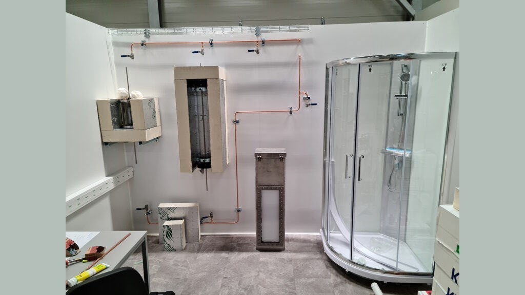 De onderzoekers realiseerden een testopstelling van een badkamer in het laboratorium. De rechthoekige doos in het midden van de foto is de thermische batterij - foto: SINTEF