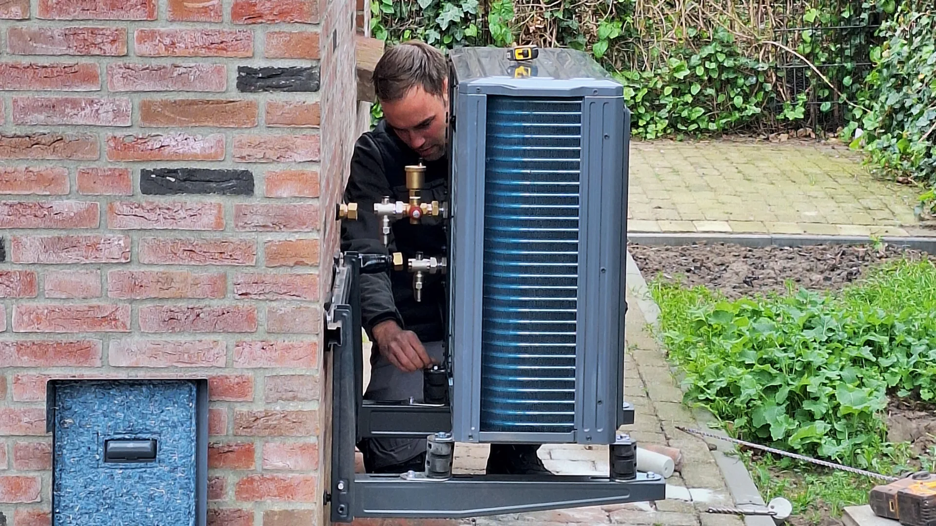 Niels de Bruijn aan het werk aan de buitenunit op beugels en dempers - foto: Margo van Voskuilen