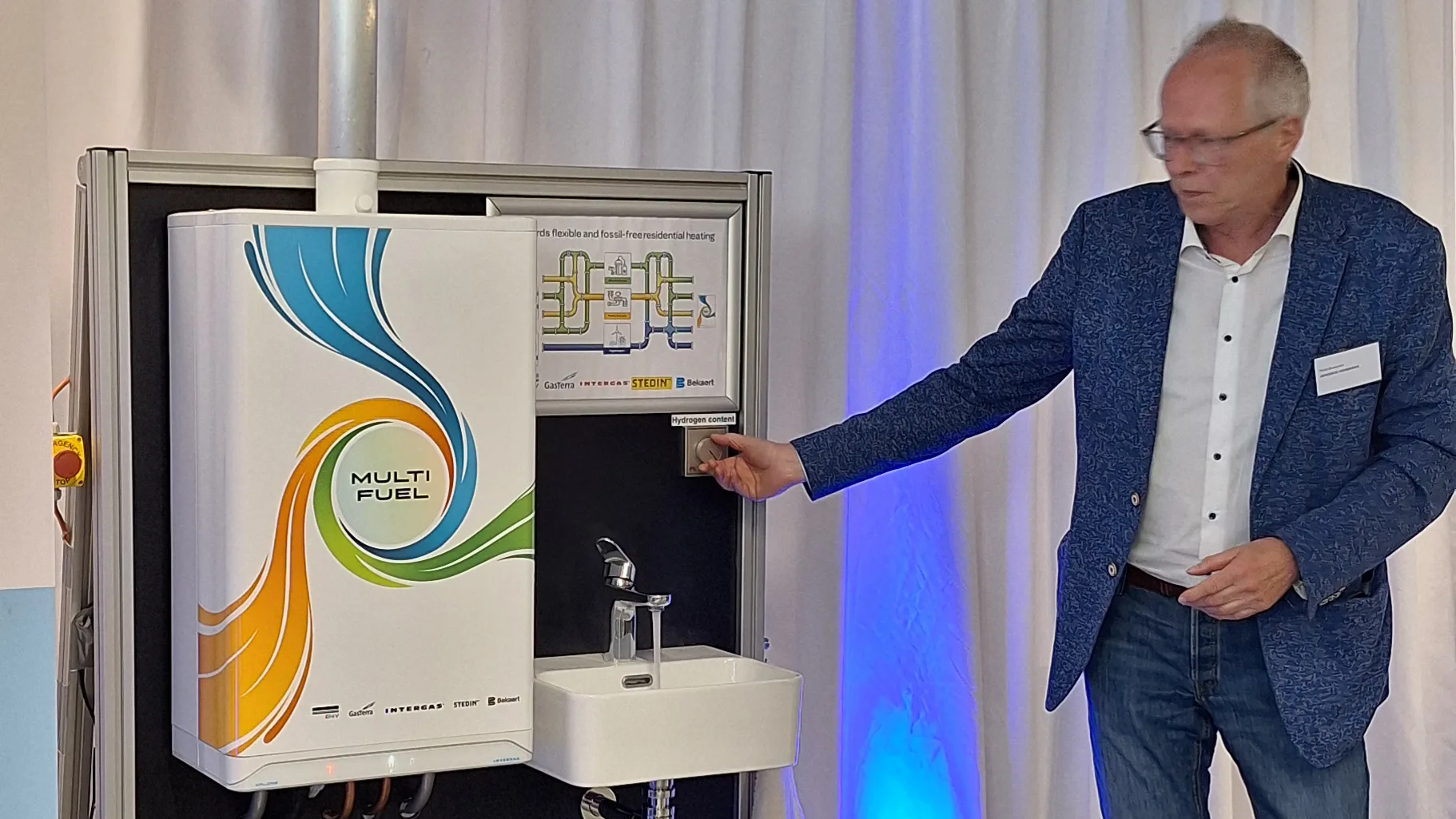 Wethouder Philip Broeksma van de gemeente Groningen draait aan de mengknop van de multifuel cv-ketel als 'openingshandeling' - foto: Margo van Voskuilen
