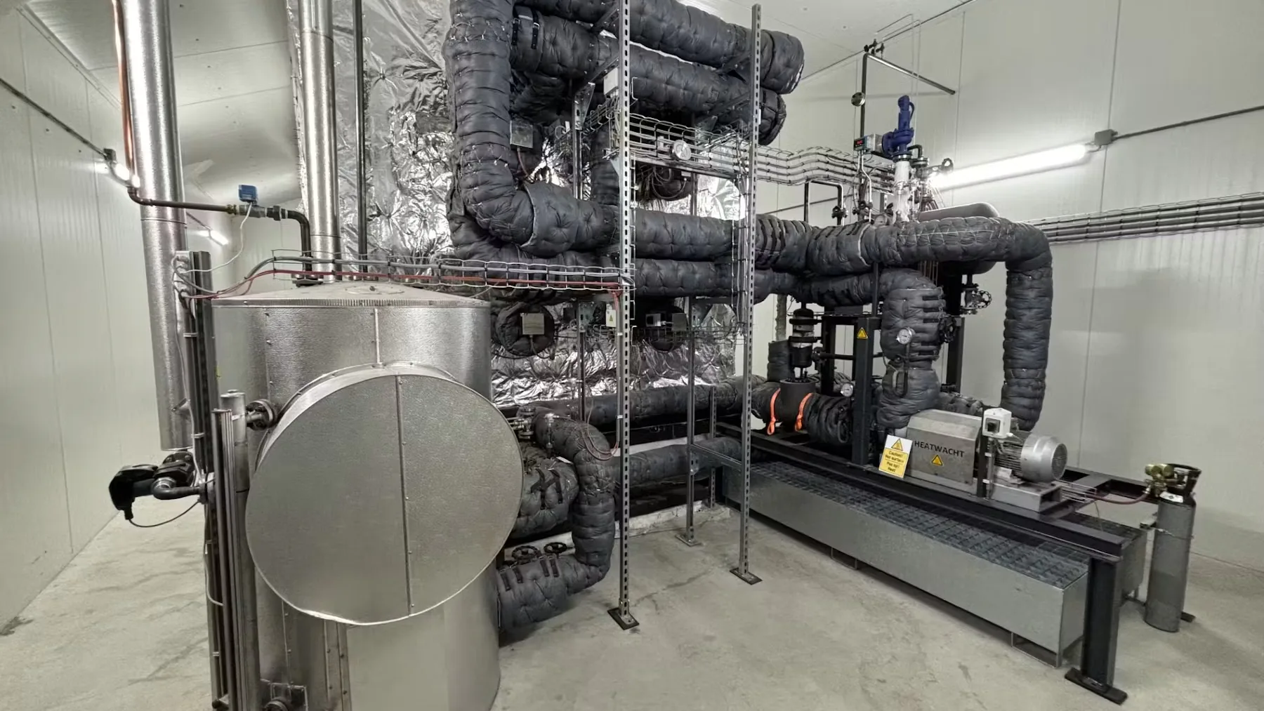 PowerStove-installatie bij Hans Wolters. Het magnetiet zit in de geïsoleerde bak achter de installatie. Het magnetiet in de bak wordt opgewarmd door de warmtewisselaars. Op deze foto staan vier wisselaars. De configuratie bij Nij Smellinghe heeft per module 42 wisselaars. Foto: Heatwacht