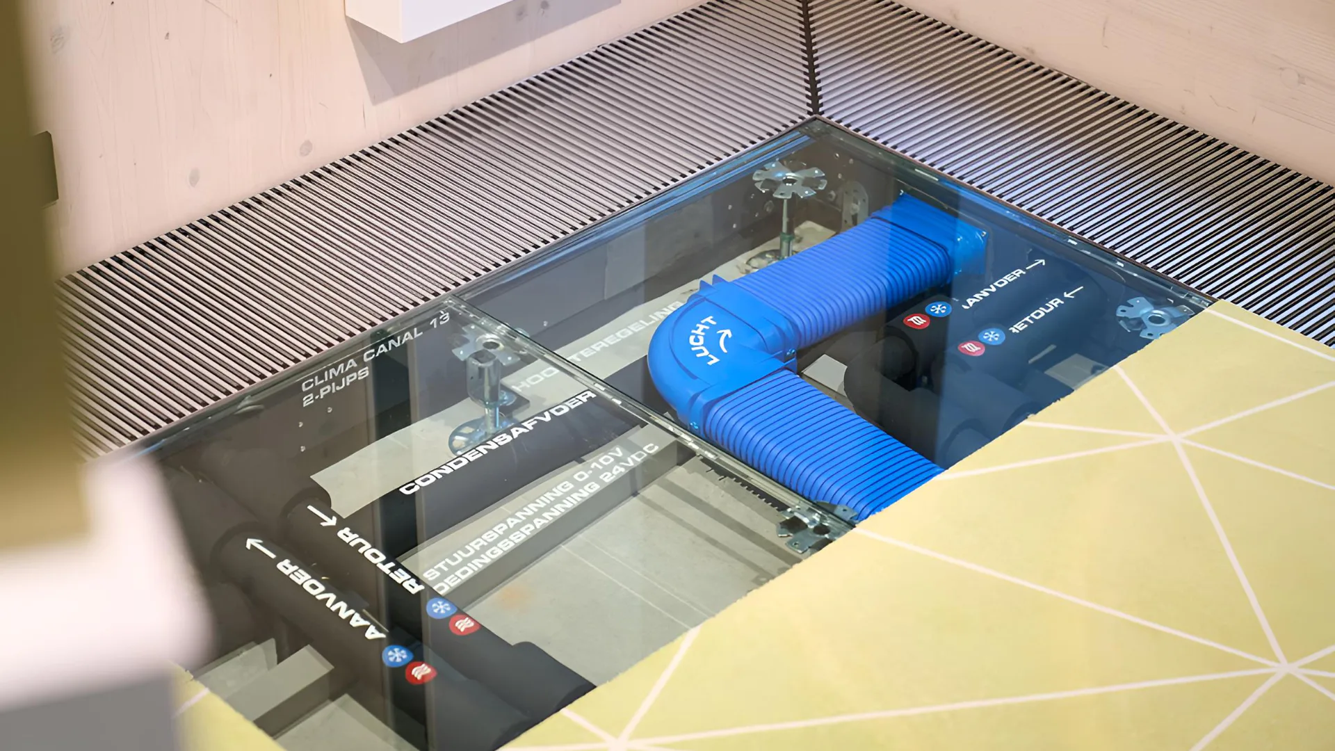JAGA gunt bezoekers een inkijkje  Kijkje onder de computervloer waarin te zien de Clima Canal met 2 pijpsaansluiting verwarmen en koelen, condensafvoer, stroomvoorziening en luchtslang aangebracht op de Clima Canal - foto: Jaga